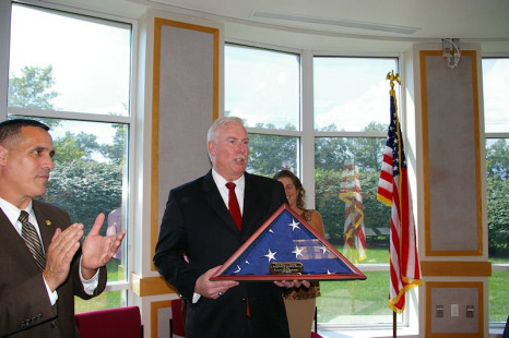 Chief of Police Robert Pomeroy accepts US flag