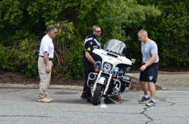 Chief, Sergeant and Cadet Look over a Motorcycle