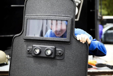 Luke Stanger, 11, struggles to hold up the heavy police shield. [Wicked Local Staff Photo/Alyssa Stone]